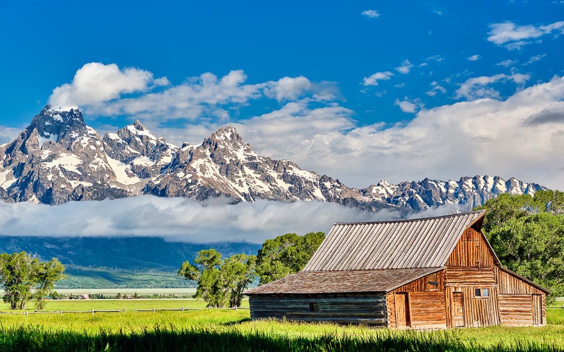 Old Mormon Barn In Grand Teton Mountains With Low Clouds. Grand